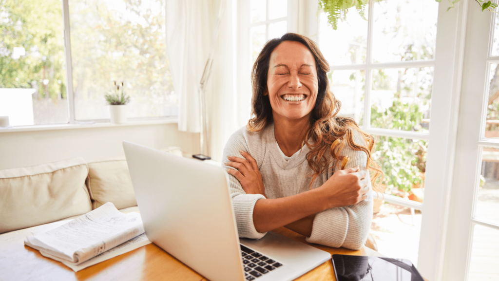 Online teacher laughing a lot in front of the computer