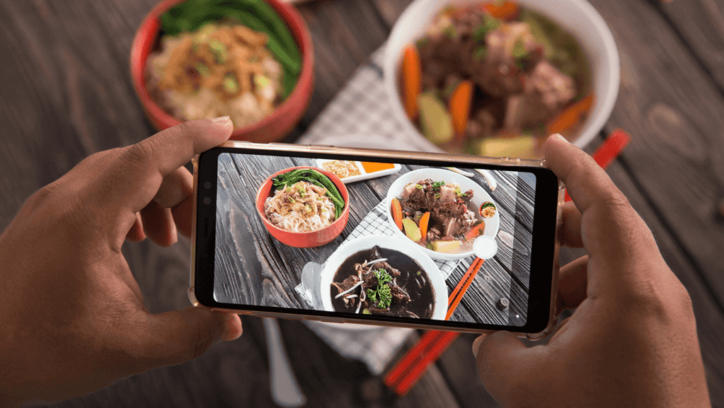 A person taking a pictur of delicious foods.